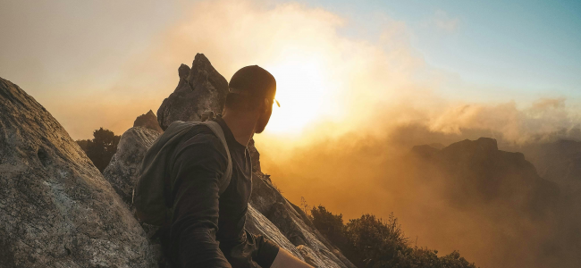 Randonneur admirant le coucher de soleil en montagne