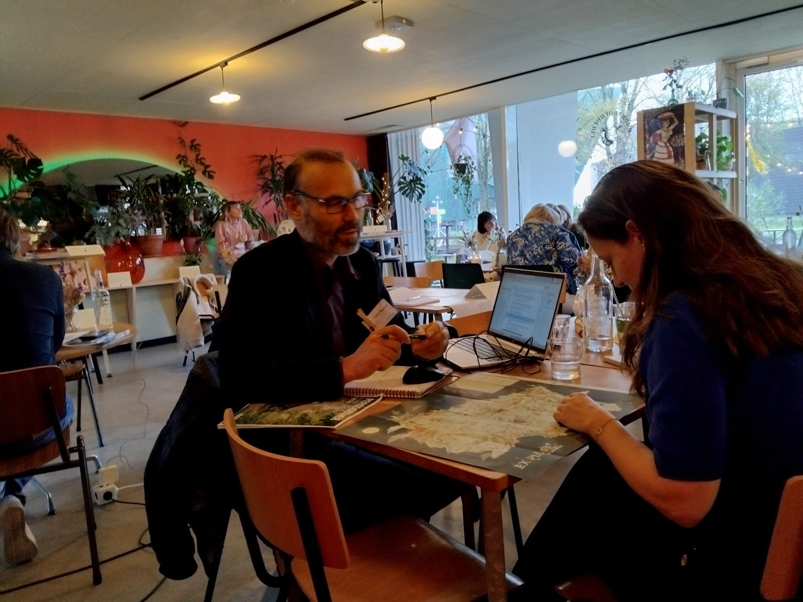 Deux personnes discutent autour d'une carte en intérieur.