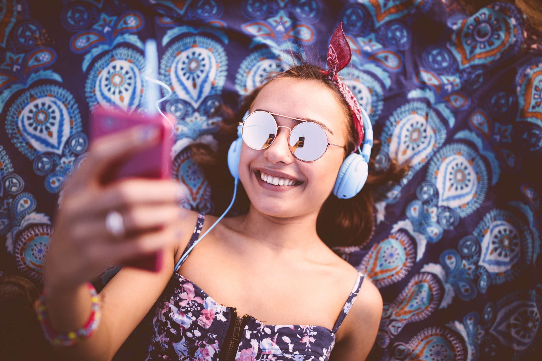 Jeune femme souriante écoutant de la musique et prenant selfie