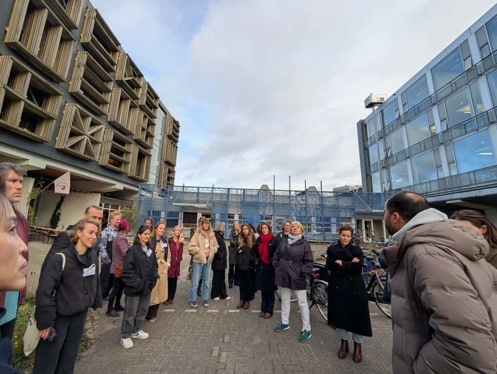 Groupe de personnes en visite urbaine entre deux bâtiments modernes