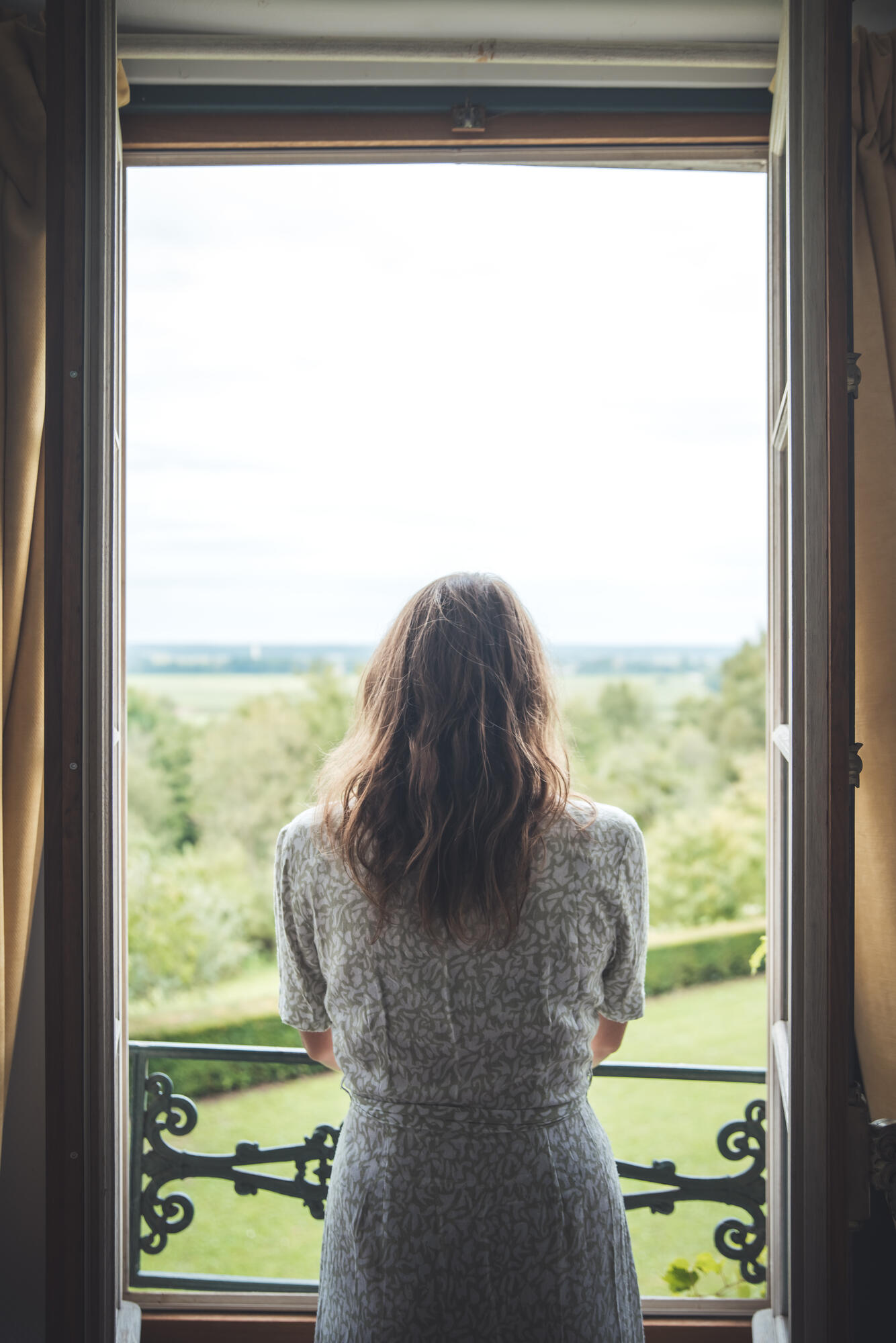 Personne regardant le paysage depuis une fenêtre ouverte