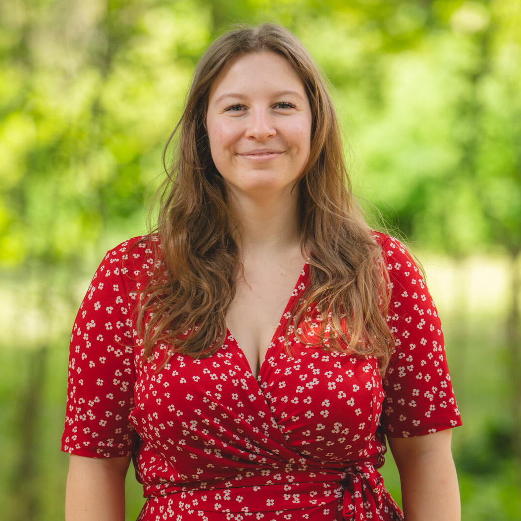 Femme souriante en robe rouge à fleurs dehors