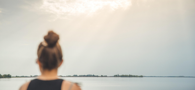 Personne regardant un lac sous la lumière du soleil