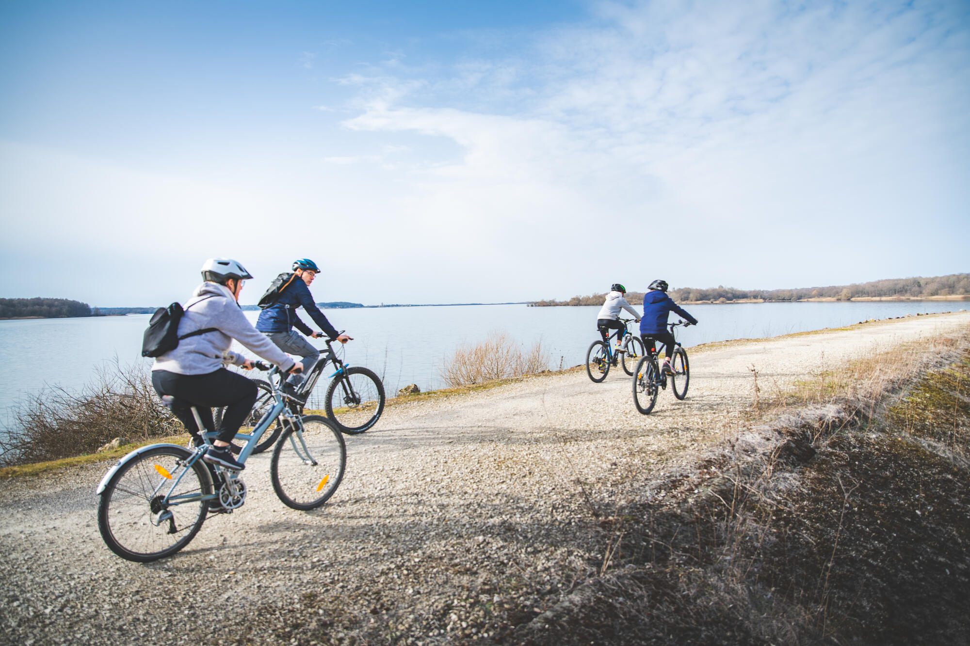 Cyclistes longeant un lac par temps clair