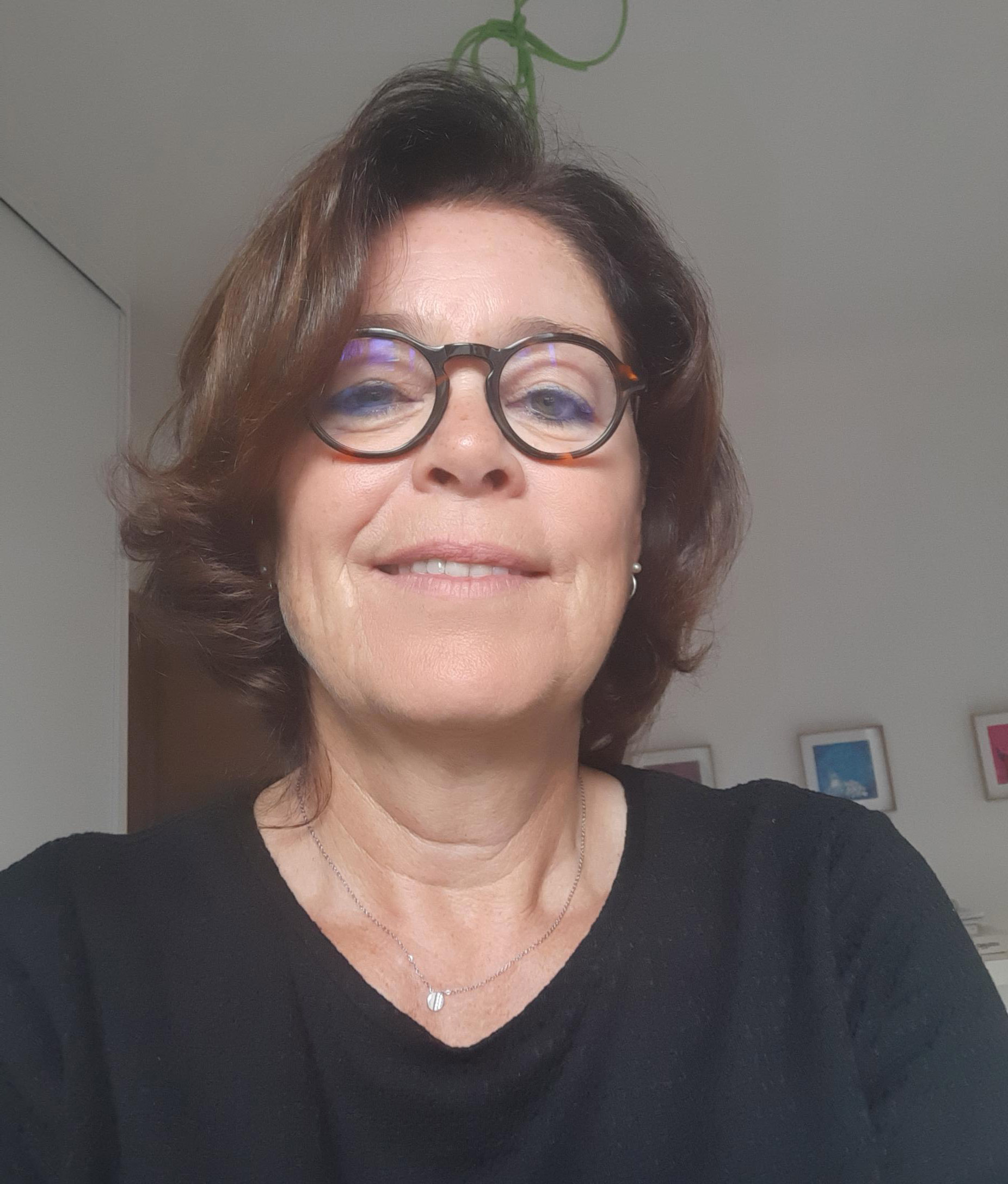 Femme souriante portant des lunettes dans une pièce claire